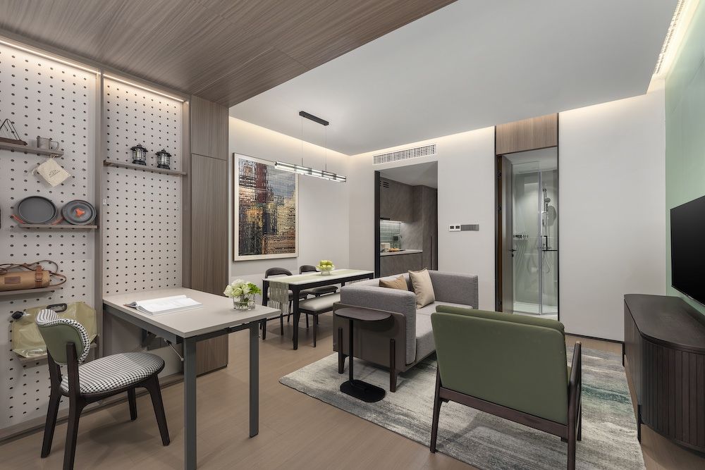 The living room in a one-bedroom deluxe unit at the premium rental apartment property Modena by Fraser Shenzhen, with an adaptable living space that features a pegboard.