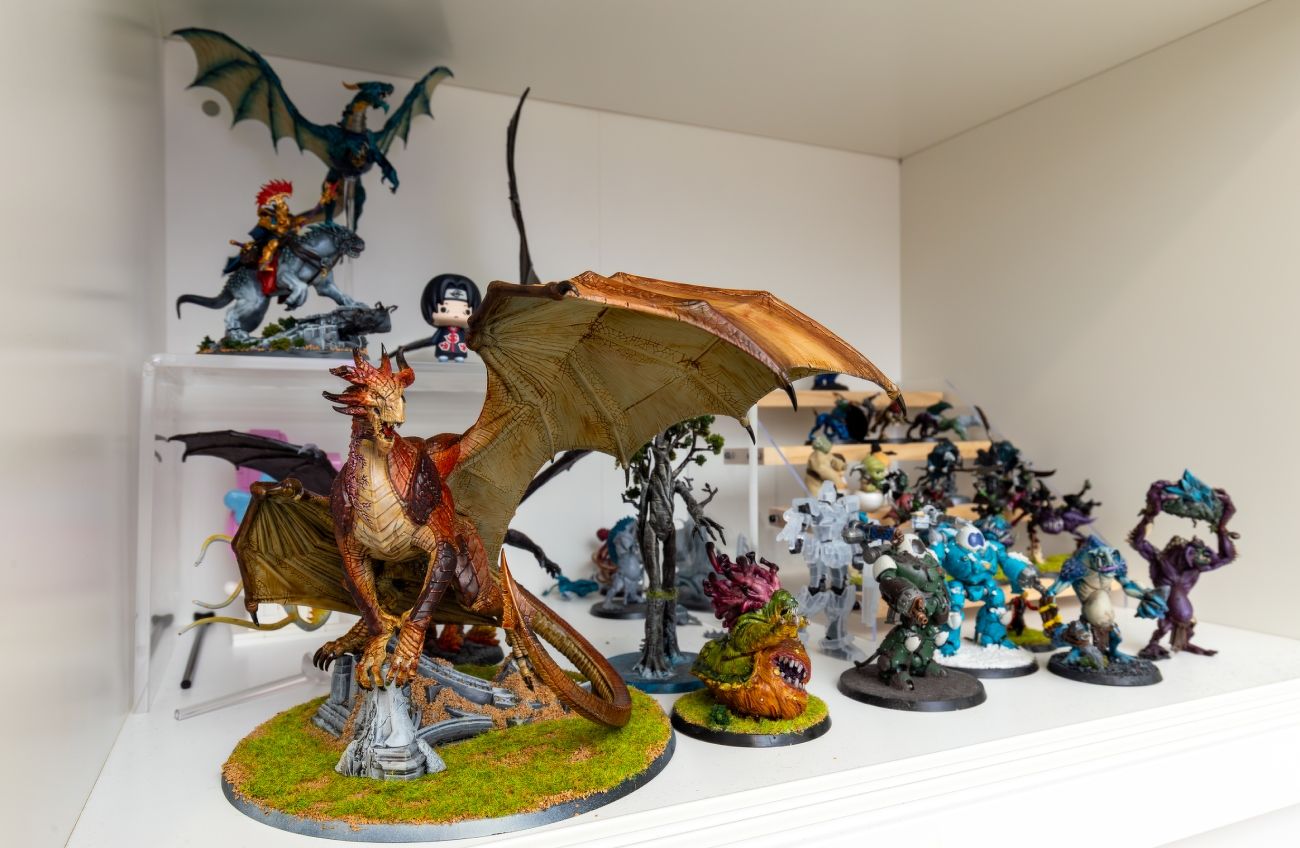 Hand-painted miniatures including a dragon and monsters, on display