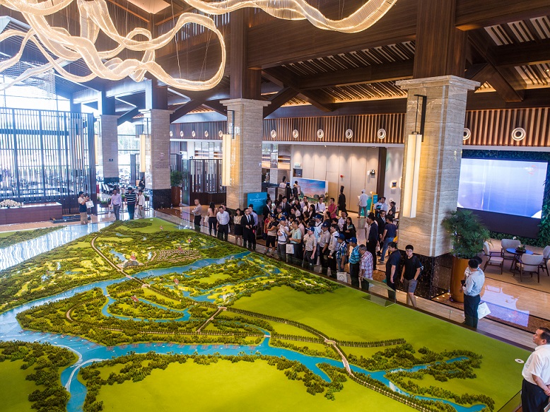 Guests look at a scale model of Forest City Golf Resort at the lobby of Forest City Golf Hotel